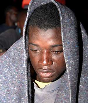 Un inmigrante llegado a Arguinegun se recupera del fro con una manta. (Foto: EFE)