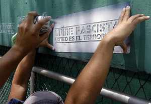 Manifestantes pintan una pared con la frase "Uribe fascista, usted es el terrorista" durante una marcha por las calles de Cali. (Foto: EFE)
