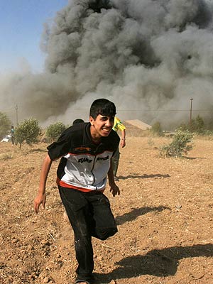 Un palestino corre en Nusseirat, en la franja de Gaza, tras un ataque israelí. (Foto: AP)
