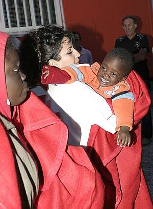 Un miembro de la Cruza Roja sostiene a uno de los bebs que viajaban en una patera. (Foto: EFE)