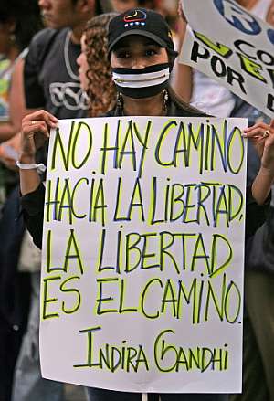 Una chica con un mensaje de Indira Gandhi en una pancarta durante una protesta en Caracas. (Foto: AFP)