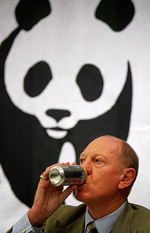 El consejero delegado de Coca-Cola, E. Neville Isdell, posa junto al logo de WWF. (Foto: AP)