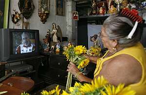Una mujer cubana prepara unas flores mientras ve en su casa la entrevista de Castro. (Foto: AP)