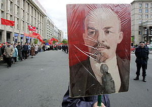 Un hombre sujeta una pancarta con la imagen de Lenin. (Foto: REUTERS)