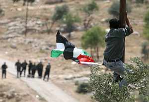 Un palestino y varios soldados israeles al fondo, en Cisjordania. (Foto: AFP)