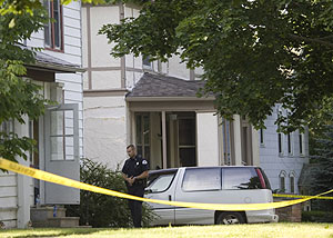 Un polica inspecciona los alrededores de la casa donde fueron encontrados los cuerpos. (Foto: AP)