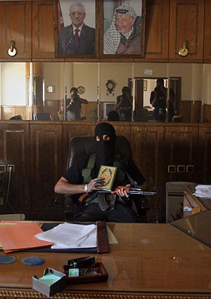 Un militante de Hamas, con una copia del Corán, en una de las sedes tomadas. (Foto: AP)