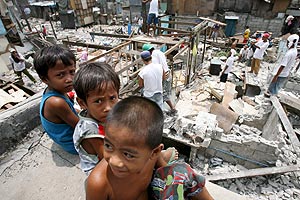 Unos nios filipinos juegan durante las labores de demolicin de un poblado de chabolas en Manila, Filipinas. (Foto: EFE)