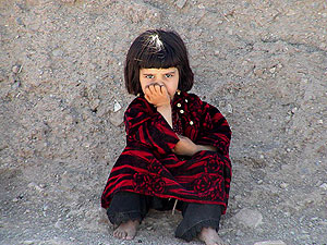 Una nia afgana espera sentada afuera de su casa, en la localidad de Heart. (Foto: EFE)