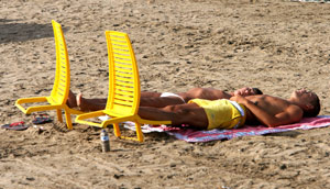 Dos personas toman el sol en la playa de la Malvarrosa. (Foto: Alberto Di Lolli)