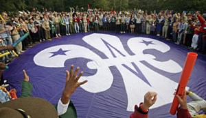 Varios scouts alrededor del emblema de la flor de lis del movimiento en la ceremonia de Brownsea. (Foto: AFP )