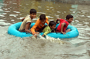 Varios niños se divierten en una barca hinchable en una carretera de Ahmadabad, en India. (Foto: AP)