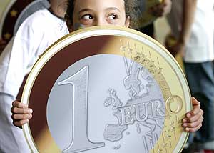 Una nia muestra una rplica gigante de una moneda de un euro. (Foto: REUTERS)