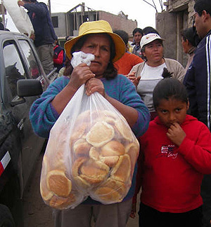 Afectados por el sesmo recogen el pan distribuido por Critas. (Foto: Critas)