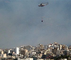 Un helicptero acude a llenar su bolsa de agua para descargarla sobre el fuego. (Foto: AP)