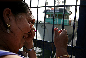 Una vecina de Barbate espera noticias en el puerto. (Foto: AFP)