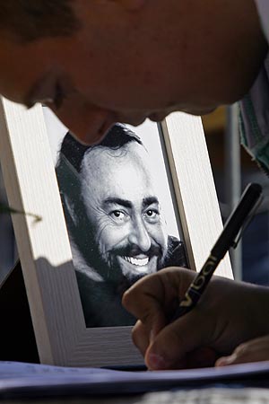 Un fan de Pavarotti firma en el libro de condolencias colocado en la capilla ardiente. (Foto: AFP)