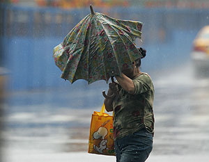 Una mujer se protege de la lluvia en Taiwn. (Foto: AP)