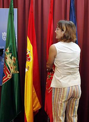 Marin Pueyo verifica que las banderas de la sala de prensa del Ayuntamiento de Pamplona han sido fijadas al suelo. (Foto: EFE)