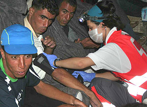 Un miembro de Cruz Roja ayuda a un inmigrante. (EFE)