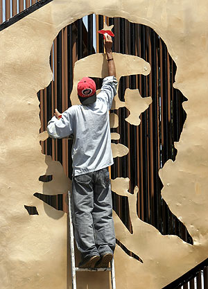Un trabajador pinta la imagen del Che en la Universidad de Managua. (Foto: AP)