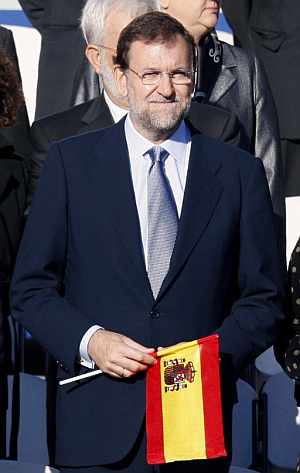 Mariano Rajoy, contempla el desfile militar con una bandera espaola. (Foto: EFE)