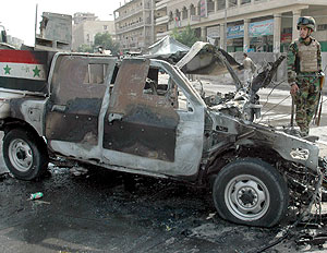 Un militar iraqu inspecciona los restos del coche bomba que hizo explosin en Bagdad. (Foto: EFE)