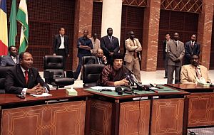 Gadafi media entre ambas partes durante la firma del acuerdo. (Foto: AFP)