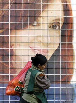 Una mujer pasa por delante de un cartel con la imagen de la candidata Cristina Kirchner. (Foto: AP)