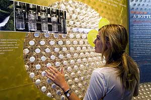 Una visitante observa el muro construido con botellas de agua en el Museo de Historia Natural de Nueva York. (Foto: EFE)