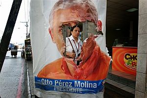 Una mujer pasa por detrás de un cartel del candidato Otto Perez Molina. (Foto: AP)
