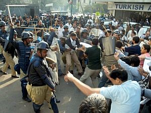 Policas se enfrentan con los periodistas que participan de una protesta contra la censura a los medios y el estado de excepcin en Karachi. (Foto: EFE)