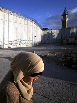 Una mujer palestina pasea por frente al muro de Cisjordania. (Foto: AP)