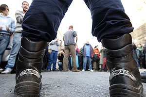 Un polica, frente a un grupo de simpatizantes de los ocupas. (Foto: EFE)