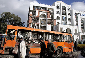 El autobús escolar y la fachada del Tribunal Constitucional tras la explosión. (Foto: EFE)