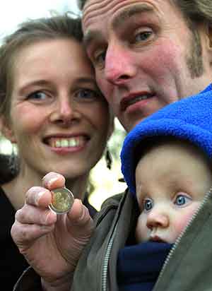 Una familia muestra una moneda de 2 euros. (Foto: Fred Ernst).
