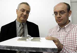 Los investigadores Xavier Obradors (izq.) y Alvar Sánchez muestran con una pieza de uno de los materiales del cable superconductor. (Foto: EFE)