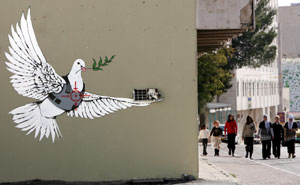 Una paloma de la paz con chaleco antibalas y un visor de un francotirador dibujado sobre su pecho en la ciudad de Beln, Cisjordania. (Foto: EFE)