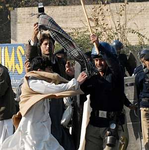 Un seguidor de Bhutto se enfrenta a un policía. (Foto: AFP)