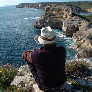El escritor Cristfol-Miquel Sbert sentado ante la cueva de s'Almoina, donde se escondan las mercancas. (Foto: Pep Vicens)