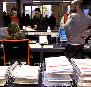 Varios jóvenes llevan sus solicitudes a una oficina de Madrid. (Foto: Carlos Alba)