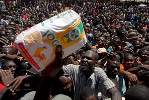 Un grupo de keniatas lucha por hacerse con un paquete de comida repartida en Nairobi. (Foto: EFE)