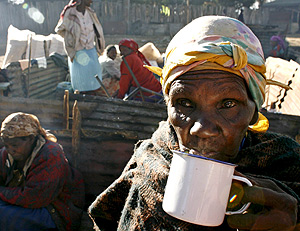 Una desplazada keniana bebe algo caliente tras los disturbios. (Foto: EFE)