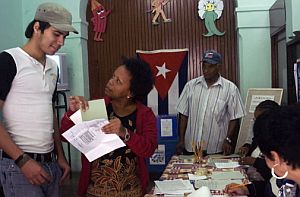 Una mujer explica el mecanismo del voto a un joven en un colegio electoral. (Foto: AFP)