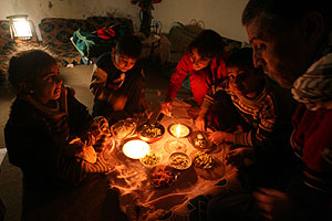 Una familia palestina intenta cenar tras el corte de luz generalizado en la franja de Gaza. (Foto: AFP)