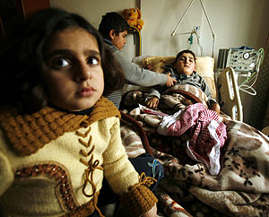 Dos nios palestinos cuidan de su hermano enfermo en Gaza. (Foto: REUTERS)