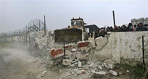Una excavadora abre un agujero en el muro fronterizo entre Gaza y Egipto. (Foto: AP)