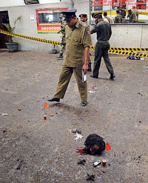 Un militar inspecciona el lugar del atentado junto a la cabeza decapitada de la terrorista. (Foto: AFP)