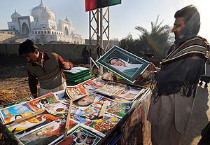 Un seguidor de Bhutto compra un poster cerca del mausleo donde est enterrada en Sindh (Pakistn). (Foto: AFP)