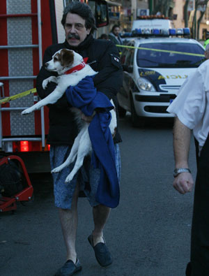 Un hombre con su perro escapa del incendio. (Foto: Jordi Avell)